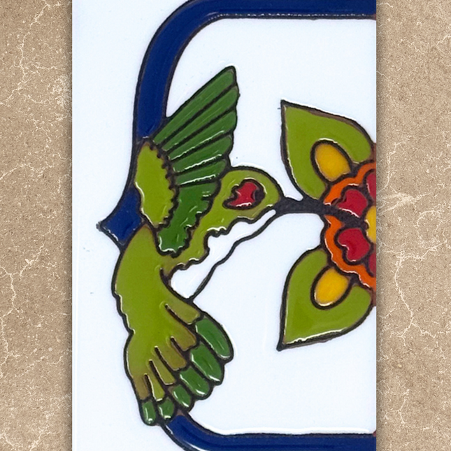 Decorative tile with a green bird, red flowers, and blue border on a beige background