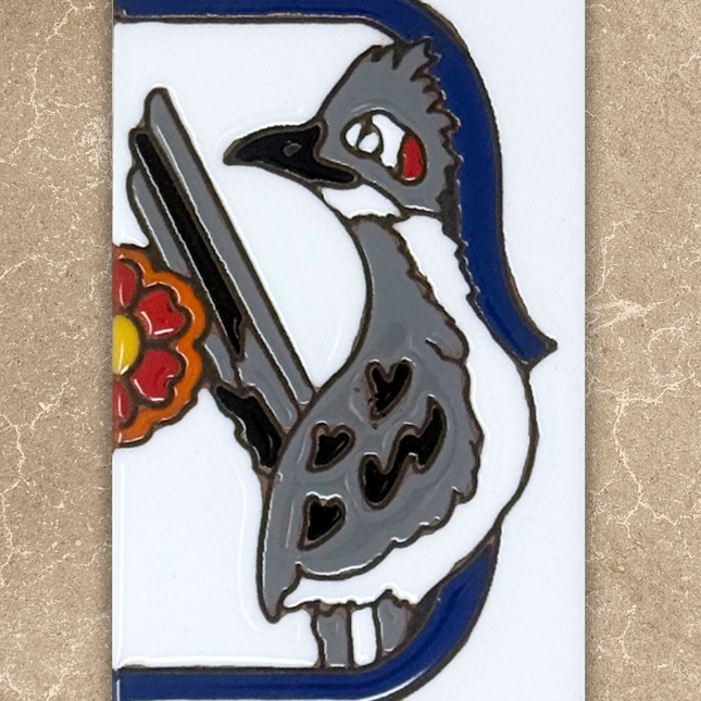 Decorative tile with a stylized bird design on a beige background