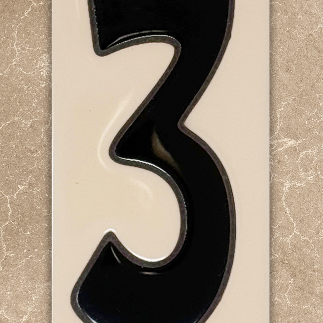 Black number '3' on a beige background