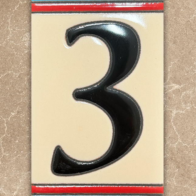 Black number '3' on a decorative card with colorful border on a beige background