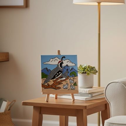 ceramic tile with a desert scene featuring a bird on a branch, with mountains and clouds in the background.