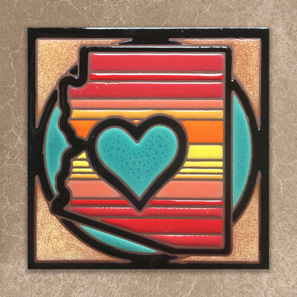 Colorful  tile with a black border on a textured beige background