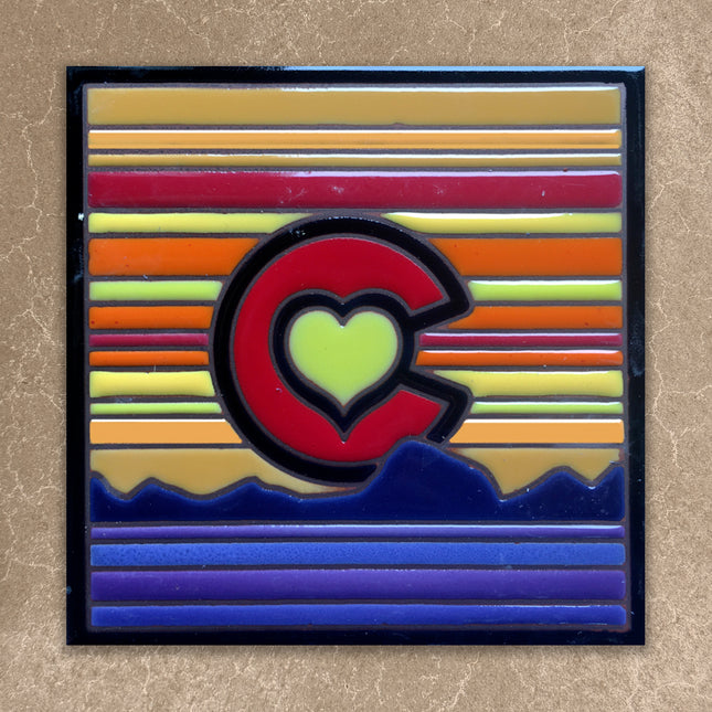 Decorative tile with a colorful 'C' design on a beige background