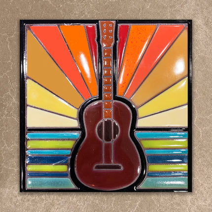 Colorful guitar-shaped object with a sunburst pattern on a beige background