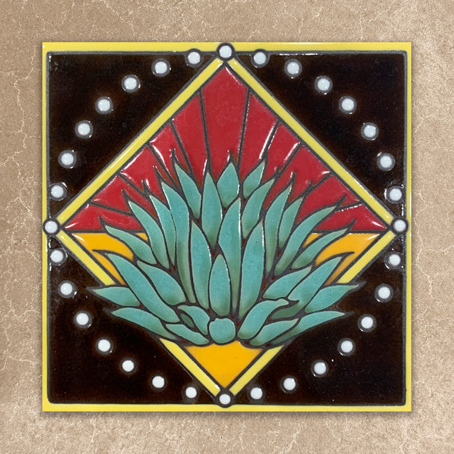 Decorative tile with a geometric design featuring a central green plant-like shape on a beige background.