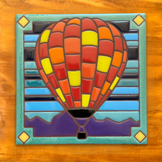 Mosaic hot air balloon art piece on a wooden background