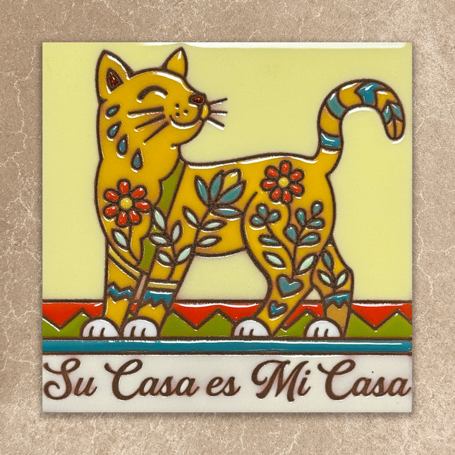 Colorful ceramic tile with a cat design and 'Su Casa es Mi Casa' text on a beige background