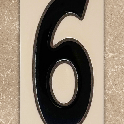 Black house number '6' on a beige background