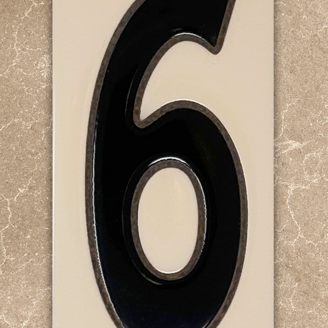 Black house number '6' on a beige background
