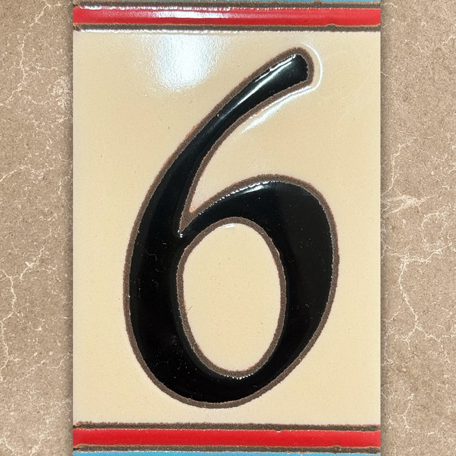 Decorative house number '6' with a colorful border on a beige background