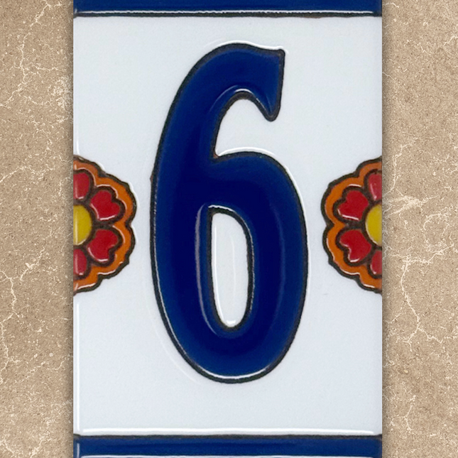 Decorative house number '6' on a ceramic tile with floral designs on a beige background