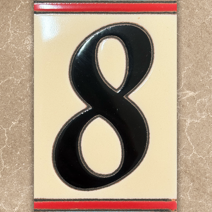 Decorative house number '8' with a colorful border on a beige background