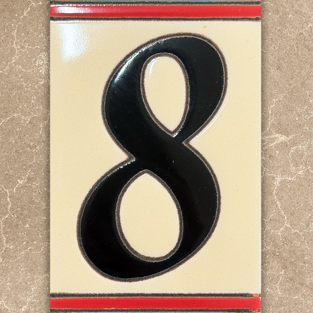 Decorative house number '8' with a colorful border on a beige background