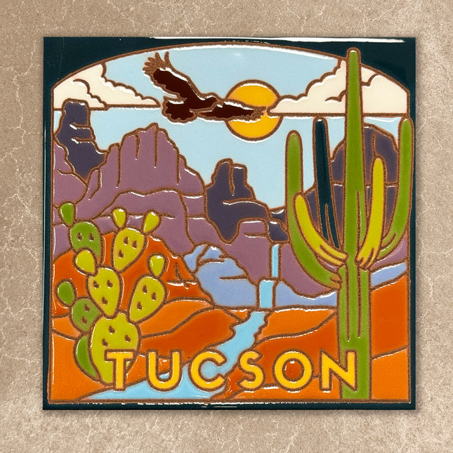 ceramic tile with desert scene featuring an eagle, cactus, and mountains, with 'Tucson' text.