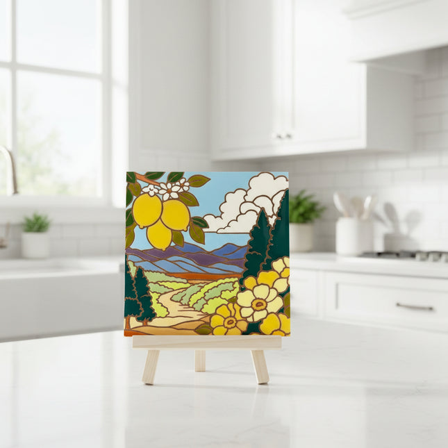 Decorative tile with a landscape design featuring lemons, flowers, and mountains on a beige background.