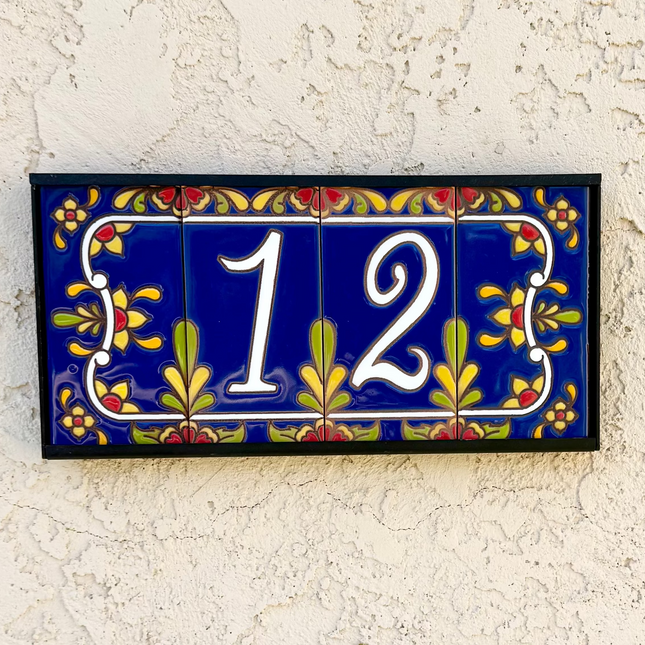 Decorative house number '12' on a textured wall with floral designs