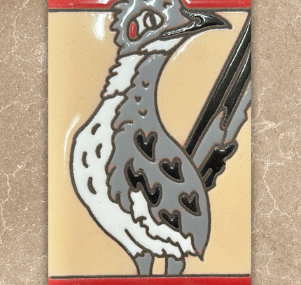 Decorative tile with a stylized bird design on a beige background