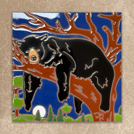 ceramic tile with a black bear climbing a tree against a blue sky.
