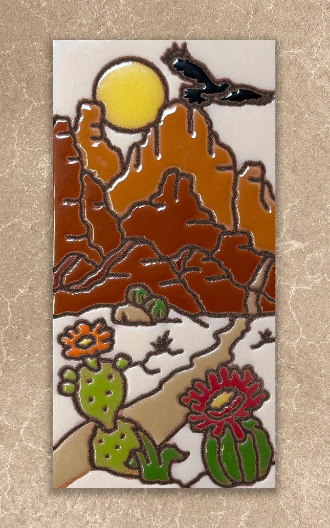 Decorative tile with desert landscape design featuring mountains, sun, cacti, and birds on a beige background.