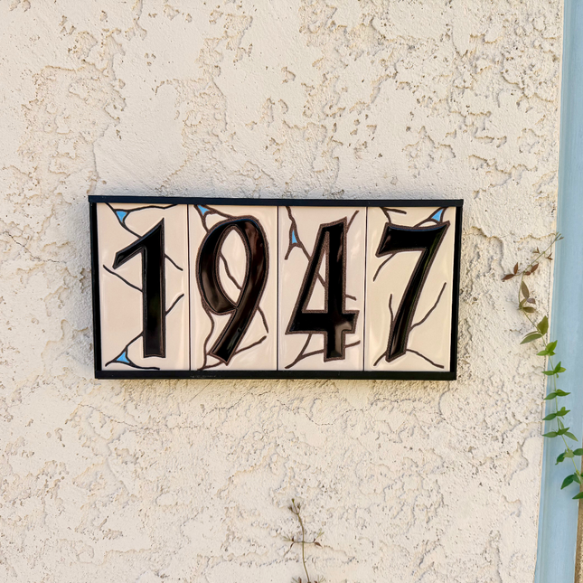 black on beige house number ceramic tile on textured wall